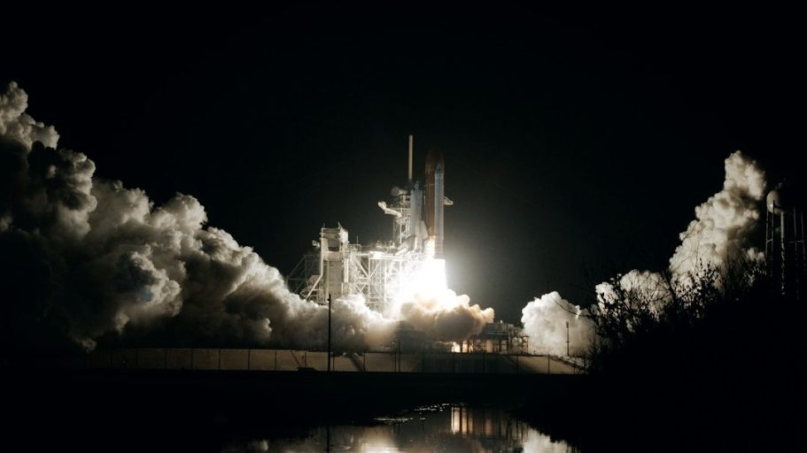 Aerospace Rakete startet in der Nacht mit großem Feuer und Rauchwolken.
